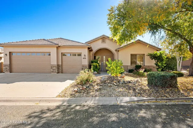 a front view of a house with a yard and potted plants