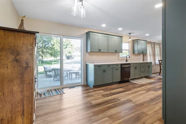 a view of kitchen with granite countertop window and wooden floor