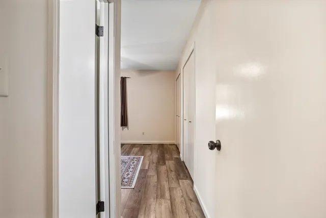 a view of a hallway with wooden floor and staircase
