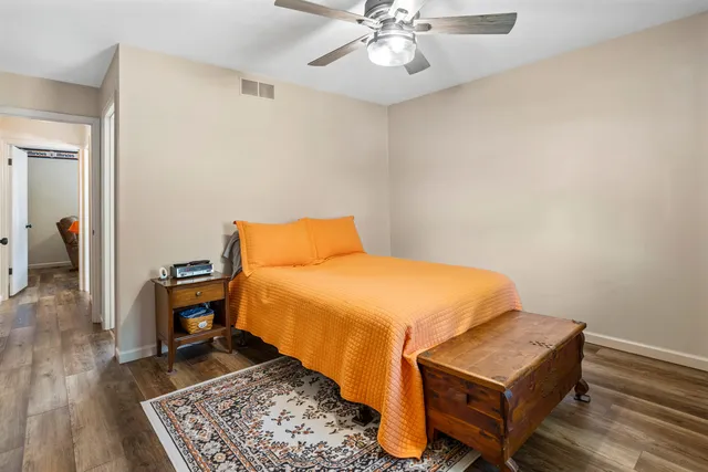 a bedroom with a bed and wooden floor