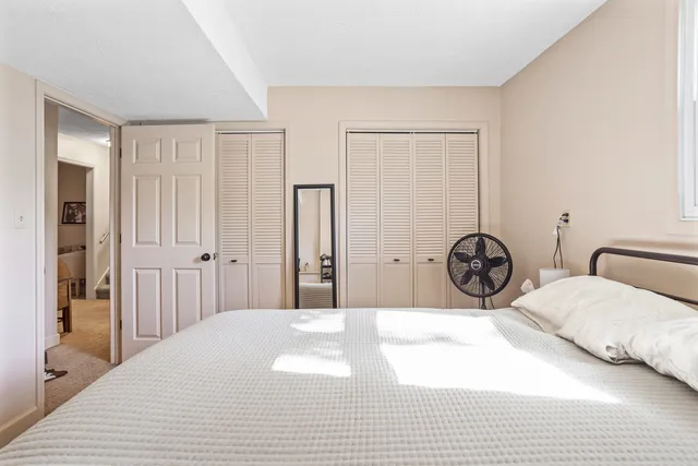 a bedroom with a bed a lamp and a large closet