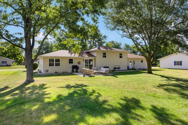 a front view of a house with a yard and trees