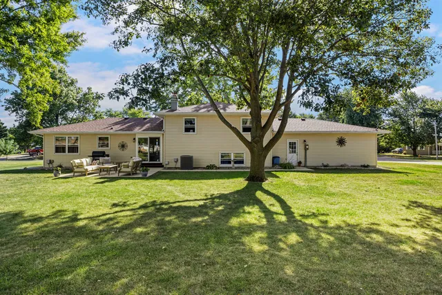 a view of a house with backyard and sitting area