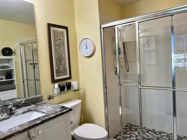 a bathroom with a granite countertop sink toilet and shower