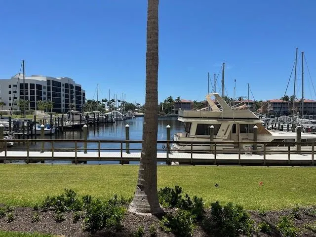 a view of a lake with lawn chairs and a table