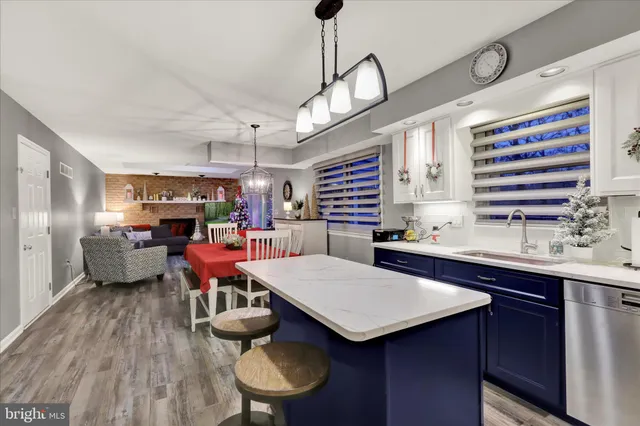 a kitchen with stainless steel appliances a table chairs in it and wooden floors