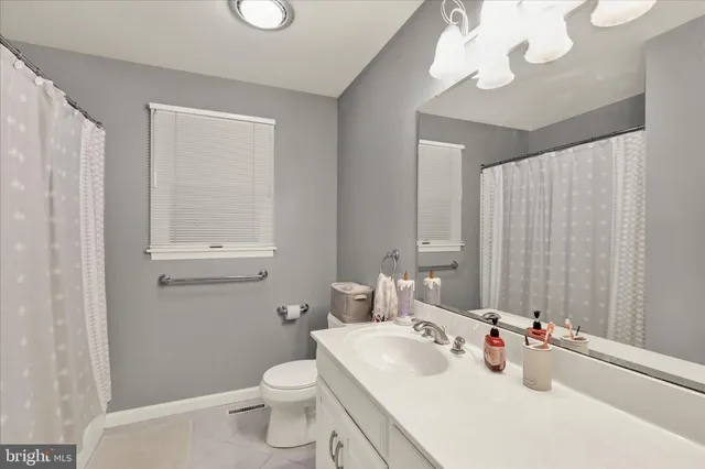 a bathroom with a sink vanity mirror and toilet