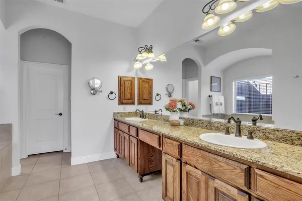 a spacious bathroom with a granite countertop sink a toilet and a mirror