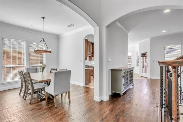 a dining room with furniture a chandelier and wooden floor