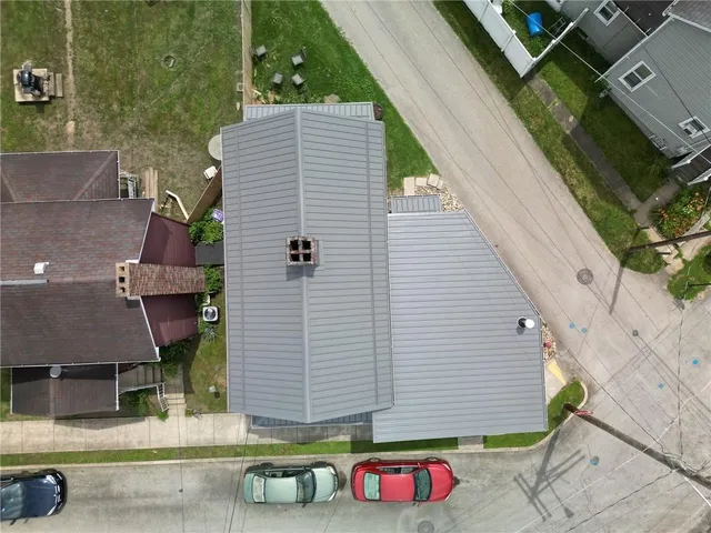 an aerial view of a house with garden space and street view