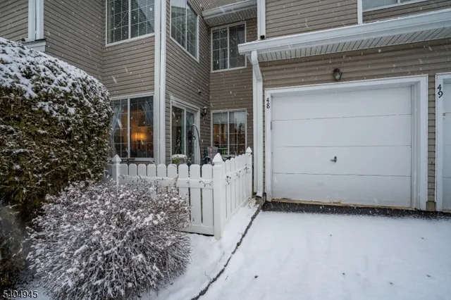 a view of a house with a large window and yard