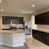 a kitchen with stainless steel appliances granite countertop a sink stove microwave and refrigerator