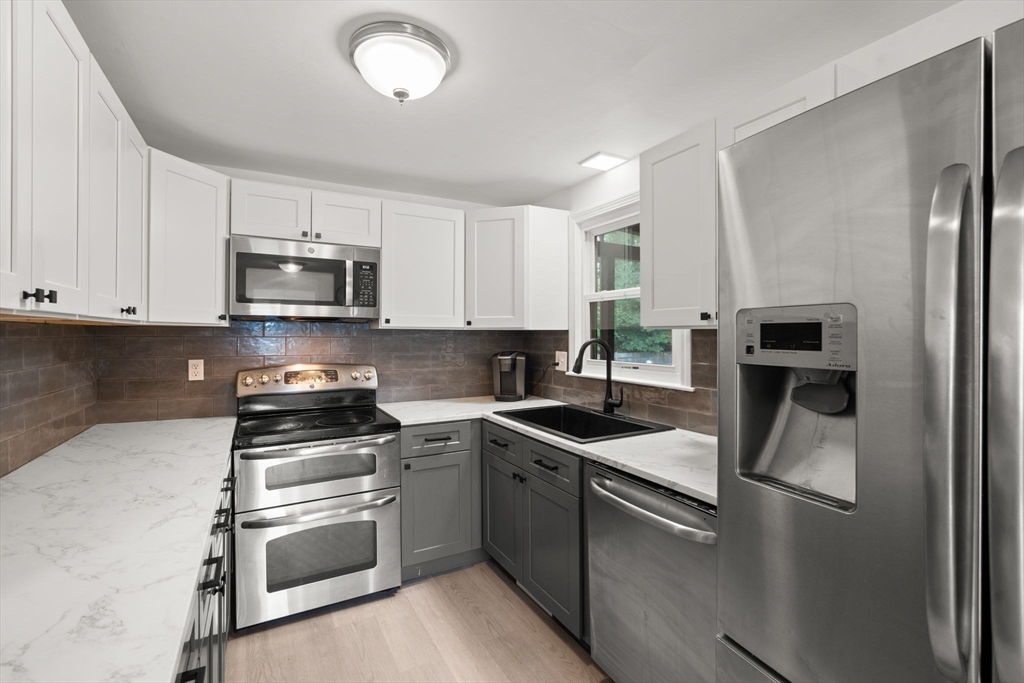 9 Laurel Lane Bellingham, MA 02019 - Photo 10 of 30 a kitchen with stainless steel appliances granite countertop a sink stove and microwave