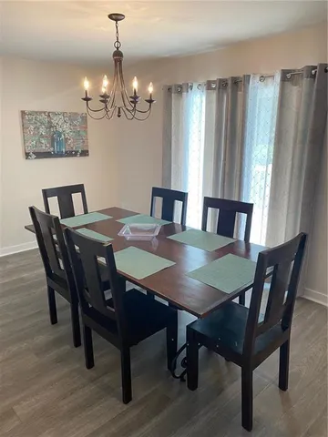 a view of a dining room with furniture a chandelier and wooden floor