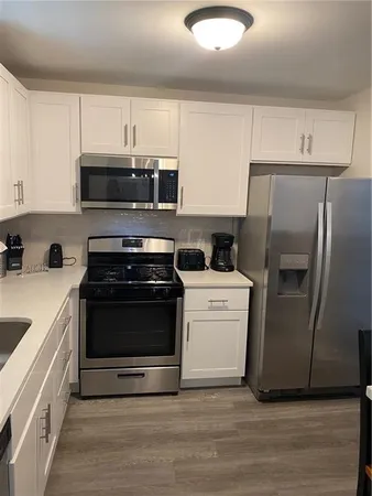 a kitchen with white cabinets and white appliances