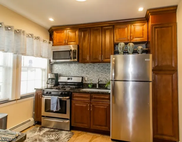 a kitchen with a refrigerator and a stove top oven