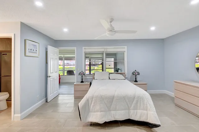 a bedroom with a bed a chandelier and a large window