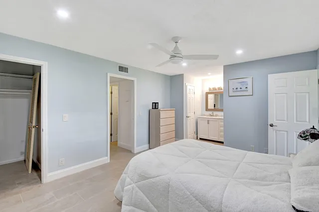 a bedroom with a large bed and a chandelier
