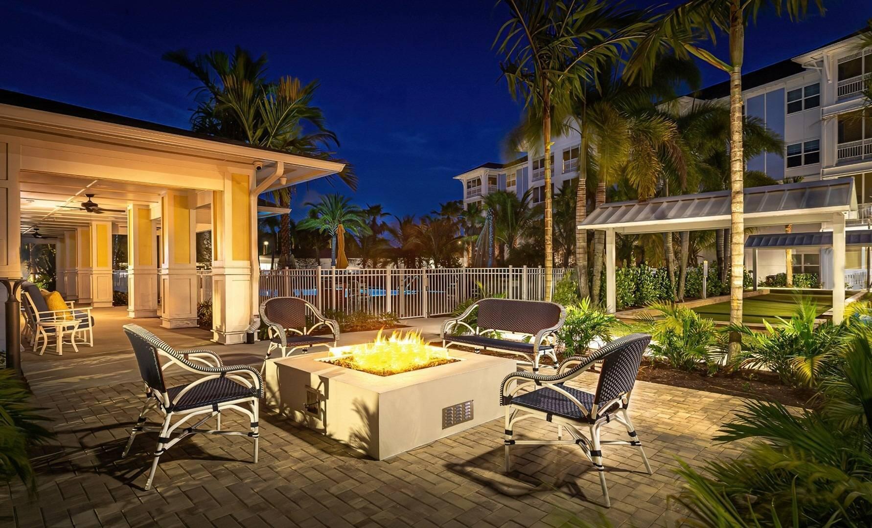 1924 Northwest Federal Highway, Unit 2101 Stuart, FL 34994 - Photo 12 of 16 a view of a chairs and table in patio with a wooden fence
