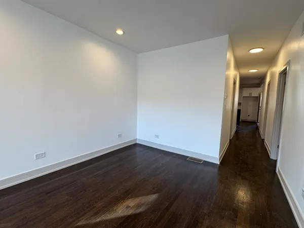 an empty room with wooden floor and entryway