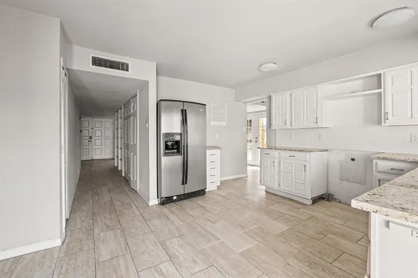 an empty room with windows and ceiling fan