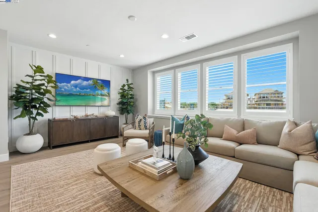 a living room with furniture potted plant and a large window