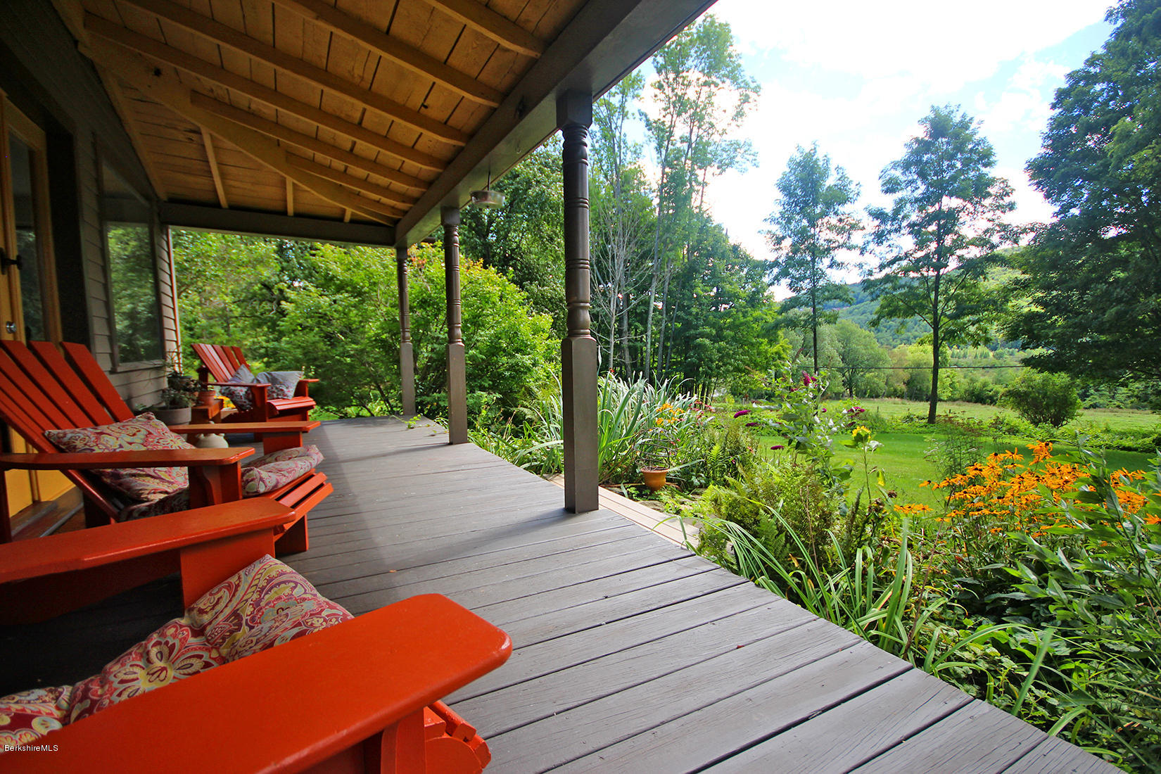 47 Main Road Tyringham, MA 01238 - Photo 30 of 31 a view of a patio with table and chairs potted plants with wooden floor and fence