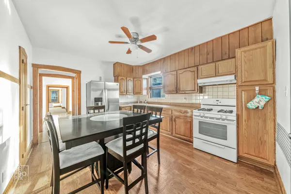 a kitchen with kitchen island a stove a table and chairs in it
