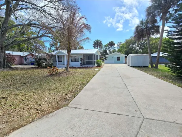 front view of a house with a yard and an trees