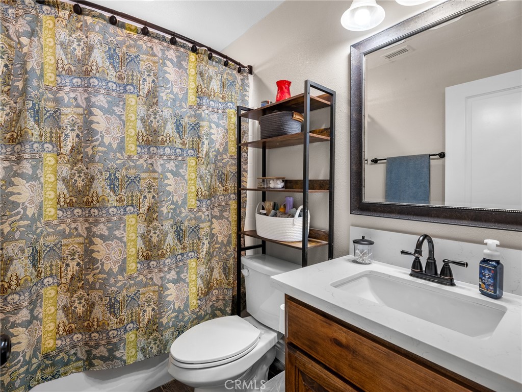 15620 Erie Road Apple Valley, CA 92307 - Photo 43 of 53 a bathroom with a sink a toilet and shower curtain
