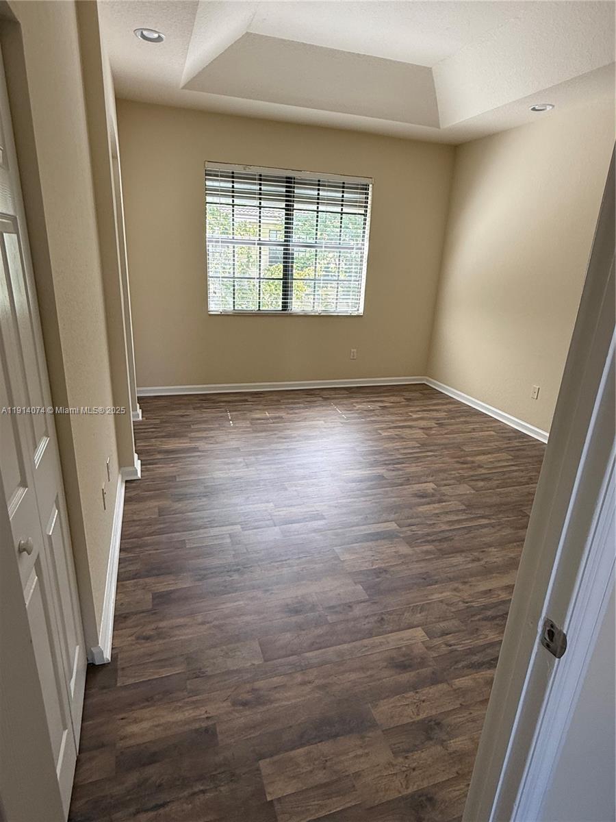 1713 Southwest Umbria Street, Unit 1713 Port St. Lucie, FL 34953 - Photo 14 of 17 a view of an empty room with wooden floor and a window