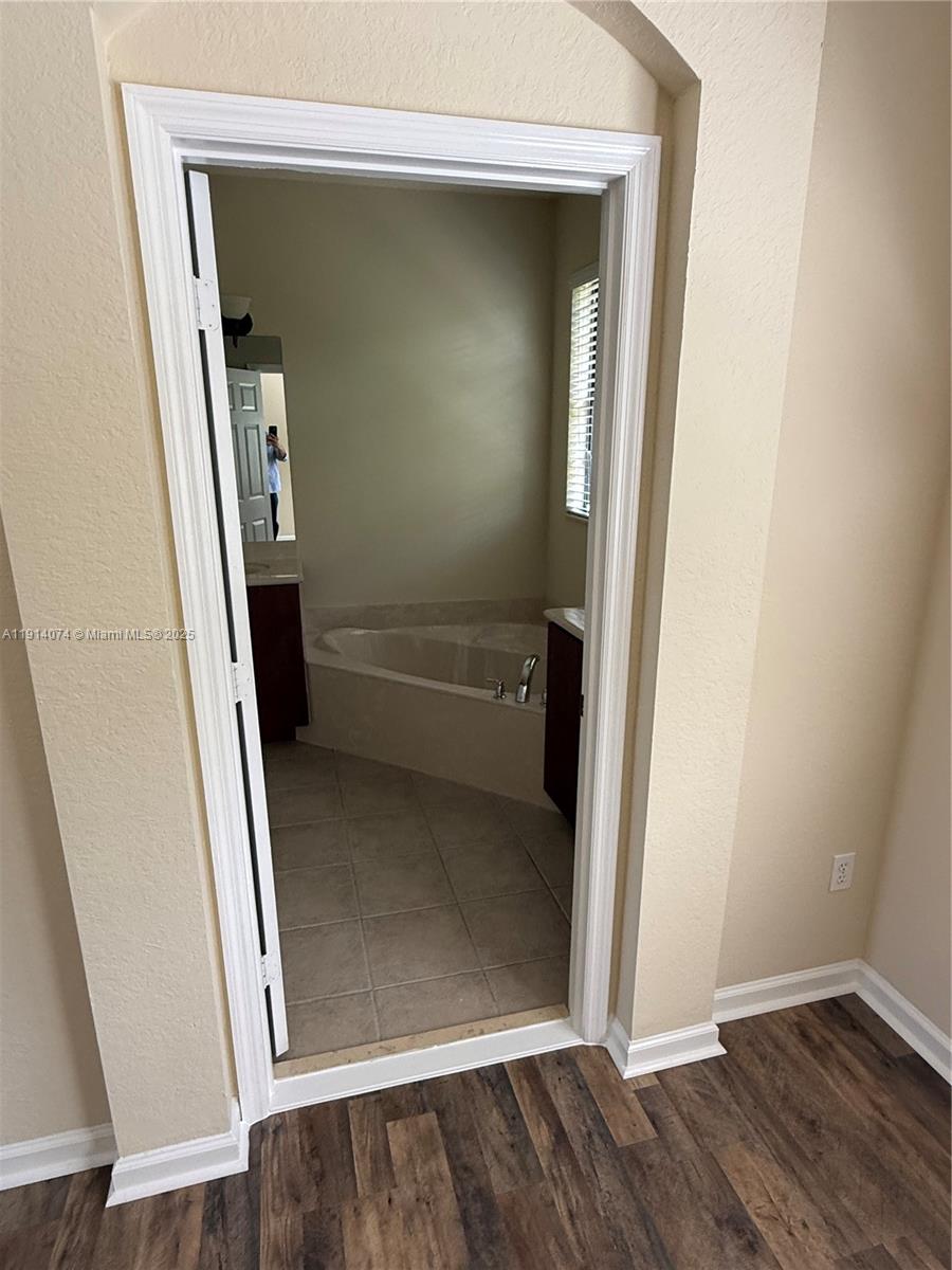 1713 Southwest Umbria Street, Unit 1713 Port St. Lucie, FL 34953 - Photo 15 of 17 an empty room with wooden floor and entrance