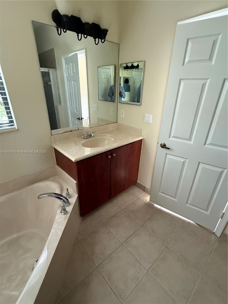 1713 Southwest Umbria Street, Unit 1713 Port St. Lucie, FL 34953 - Photo 17 of 17 a bathroom with a granite countertop sink a toilet and mirror
