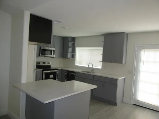 a kitchen with a sink a stove a microwave and cabinets