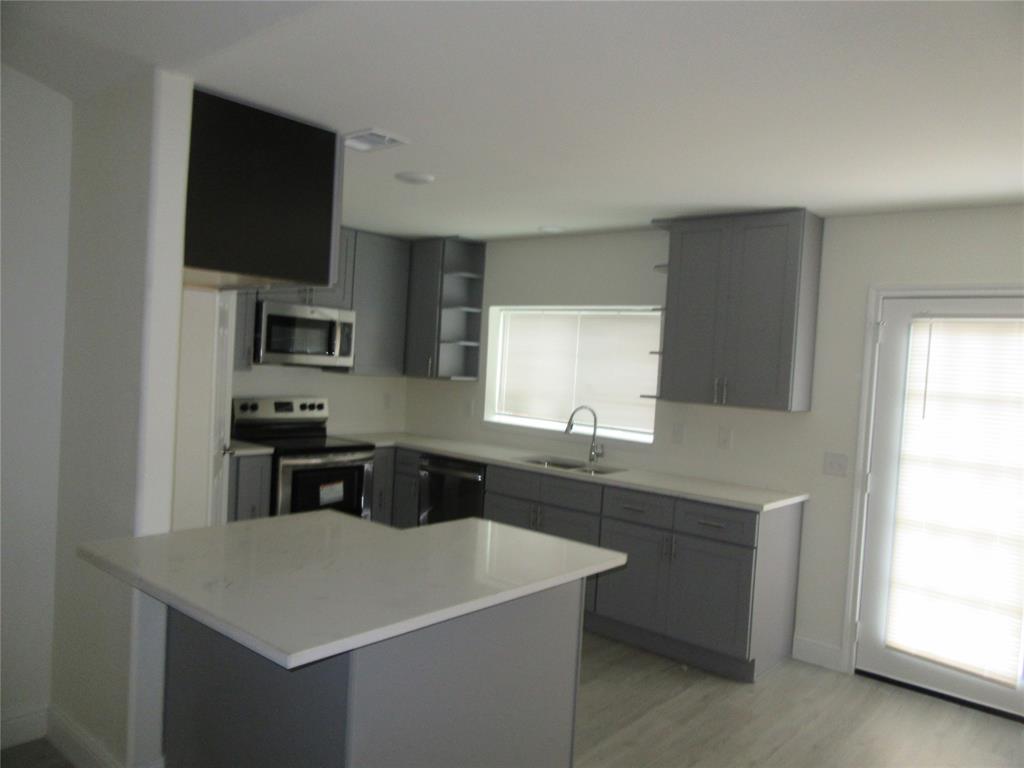 2209 Merrimac Lane Lancaster, TX 75146 - Photo 10 of 11 a kitchen with a sink a stove a microwave and cabinets