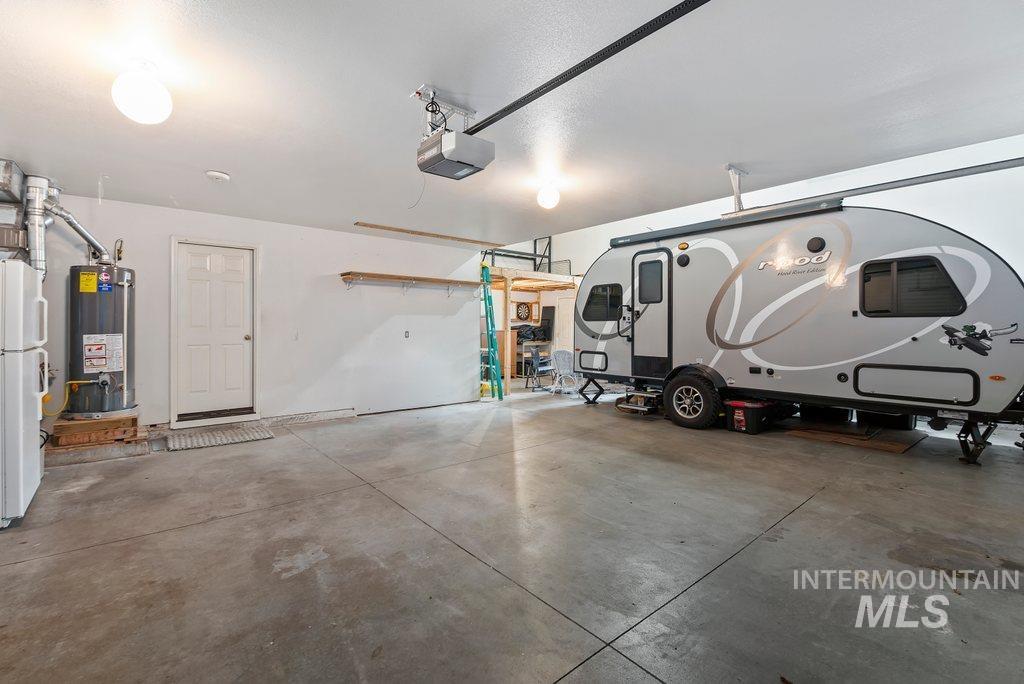 2415 South Georgetown Way Boise, ID 83709 - Photo 33 of 38 Garage with freestanding refrigerator, water heater, and a garage door opener