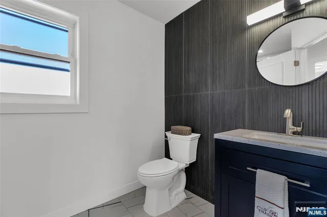 a bathroom with a toilet a sink and mirror