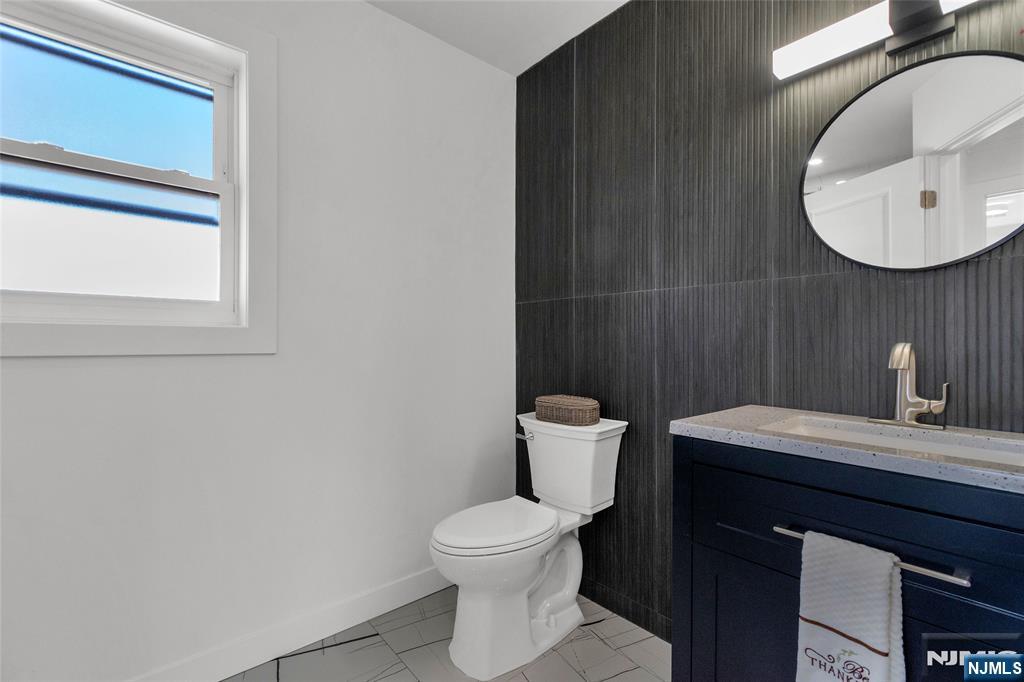 784 Valley Street Union, NJ 07088 - Photo 15 of 20 a bathroom with a toilet a sink and mirror