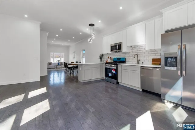 a kitchen with stainless steel appliances kitchen island granite countertop a sink and cabinets