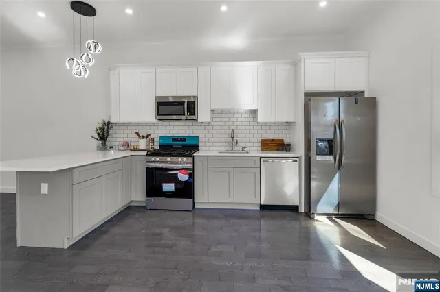 a kitchen with stainless steel appliances granite countertop a refrigerator and a stove top oven