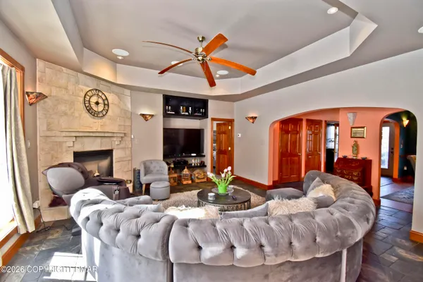 a living room with furniture a fireplace and a large window