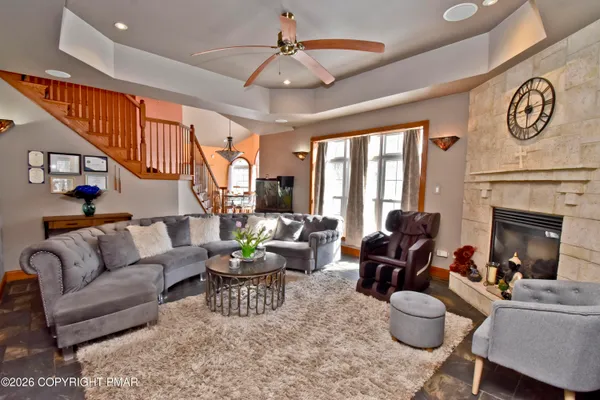 a living room with furniture a fireplace and a chandelier