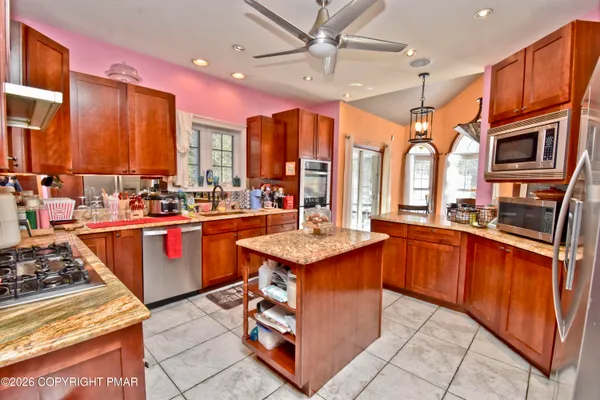 a kitchen with stainless steel appliances granite countertop a stove a sink dishwasher and a refrigerator