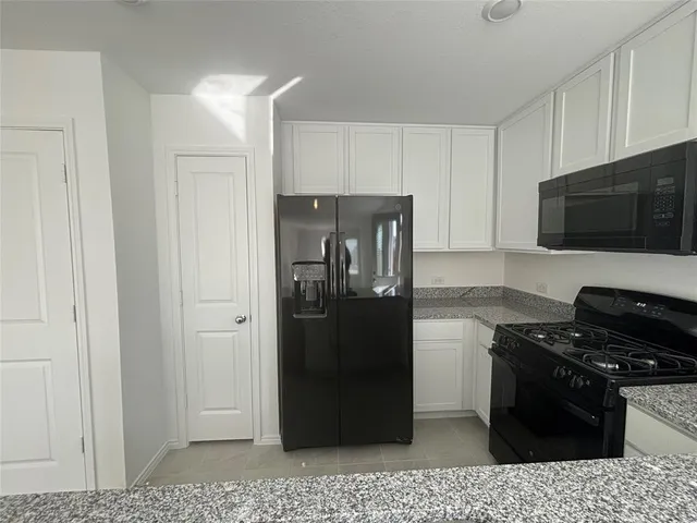 a kitchen with a refrigerator stove and cabinets
