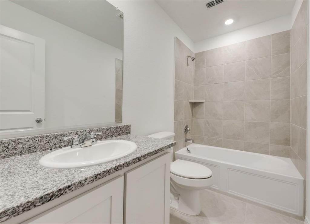 9832 Trusler Road Fort Worth, TX 76179 - Photo 9 of 13 a bathroom with a granite countertop sink toilet a mirror and a bathtub