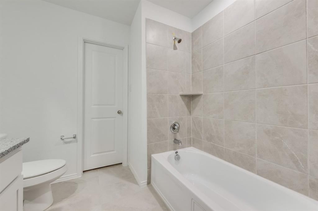 9832 Trusler Road Fort Worth, TX 76179 - Photo 10 of 13 a bath room with a toilet sink and a bath tub