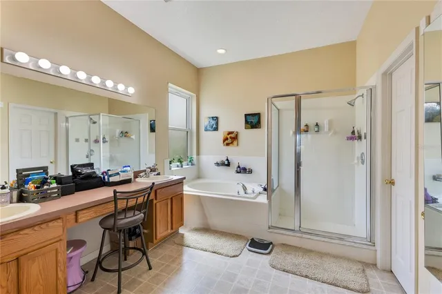 a bathroom with a tub a sink a mirror and a shower