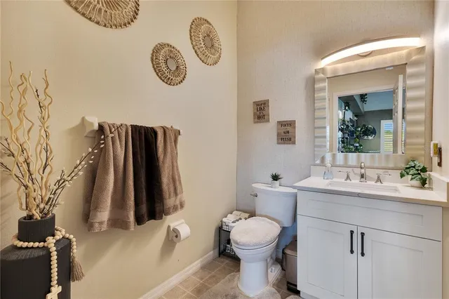a bathroom with a toilet sink vanity and mirror