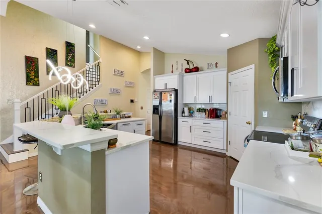 a kitchen that has a lot of cabinets a sink and appliances