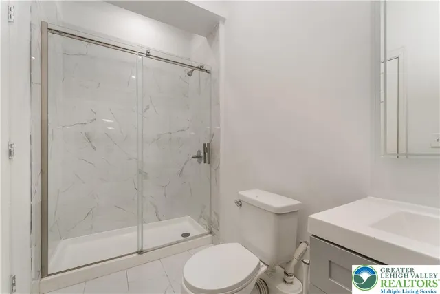 a white toilet next to a bathroom
